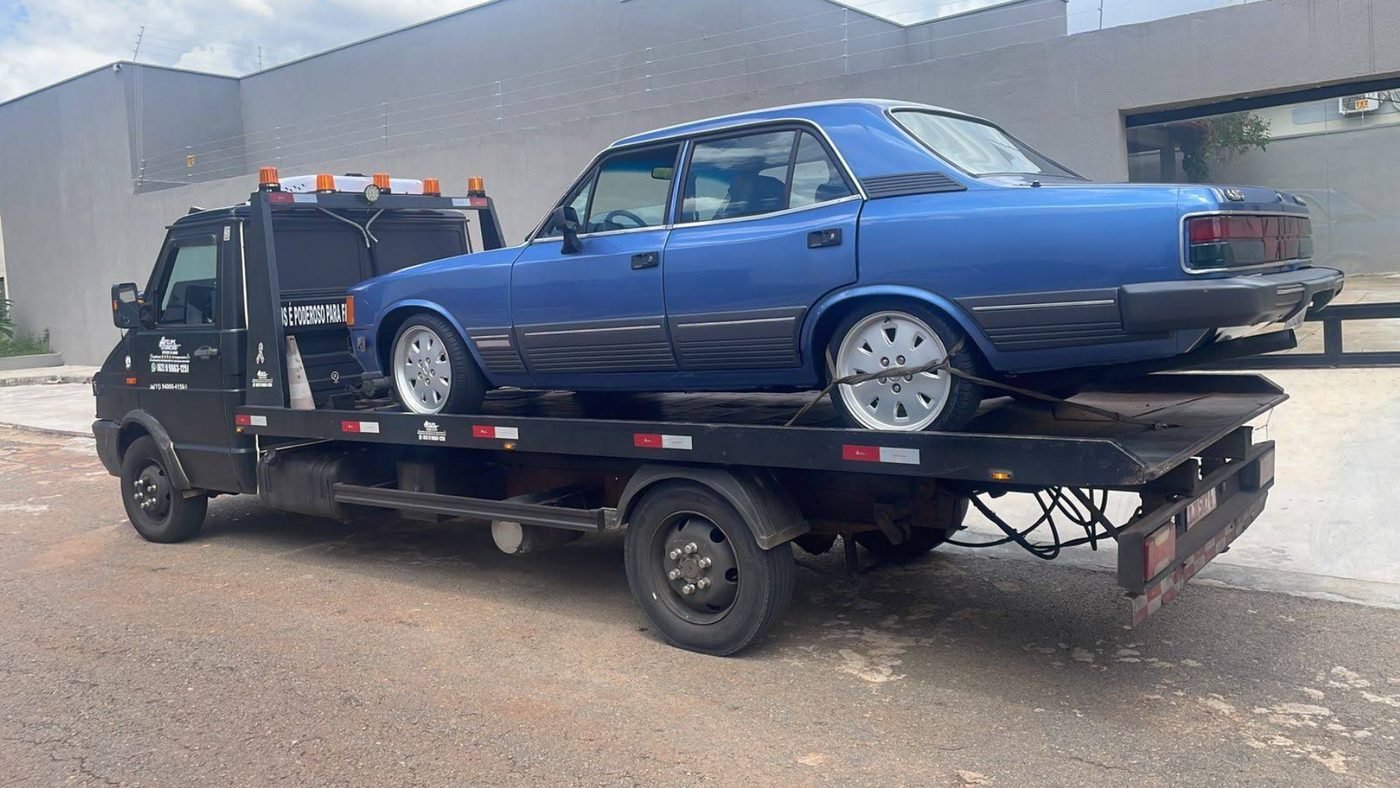 Guincho plataforma transportando Chevrolet Opala azul