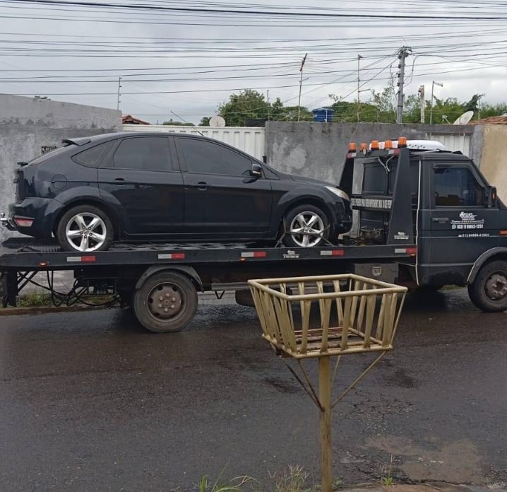 Reboque de Ford Focus preto sobre plataforma